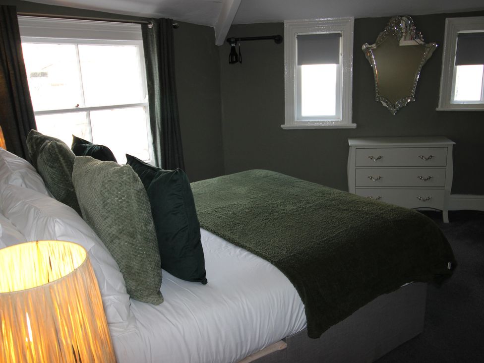 A bedroom with a bed and dresser at Cornerhouse Apartment 1 in Llandudno