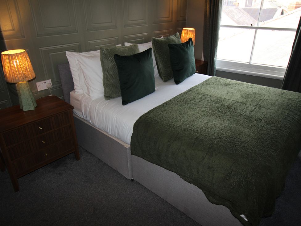 A bedroom with a bed and table lamp at Cornerhouse Apartment 1, Llandudno