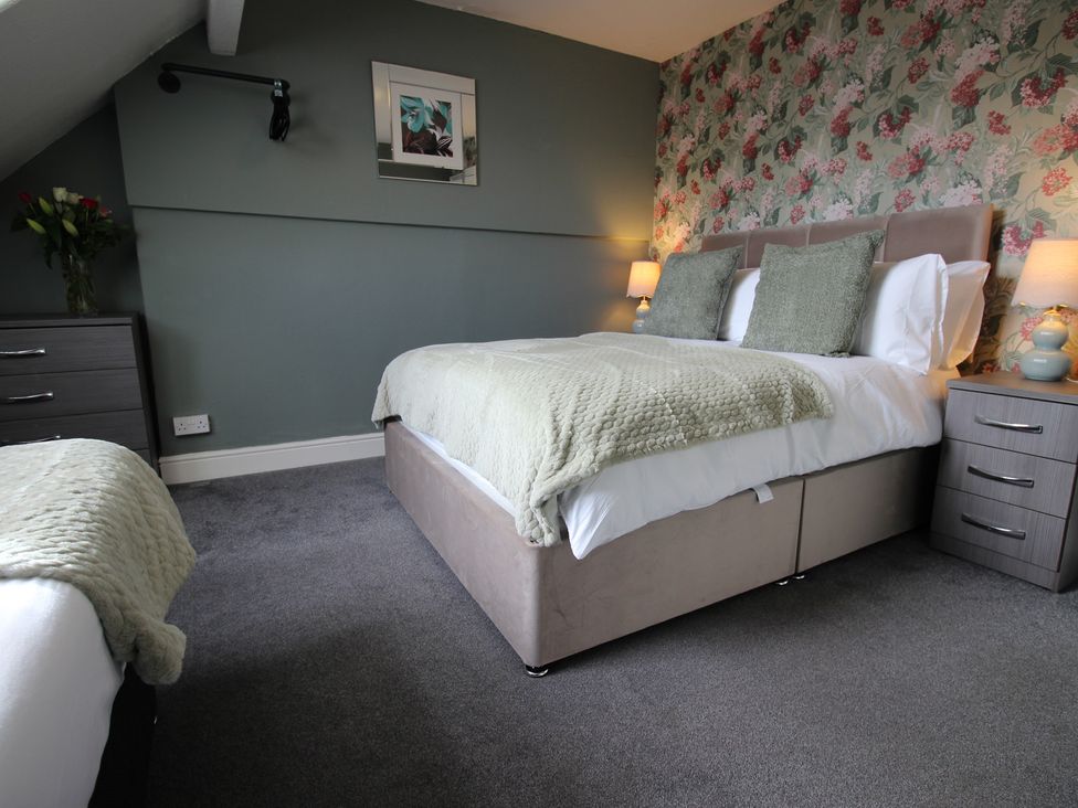 A bedroom with a bed and nightstand at Cornerhouse Apartment 1 Llandudno