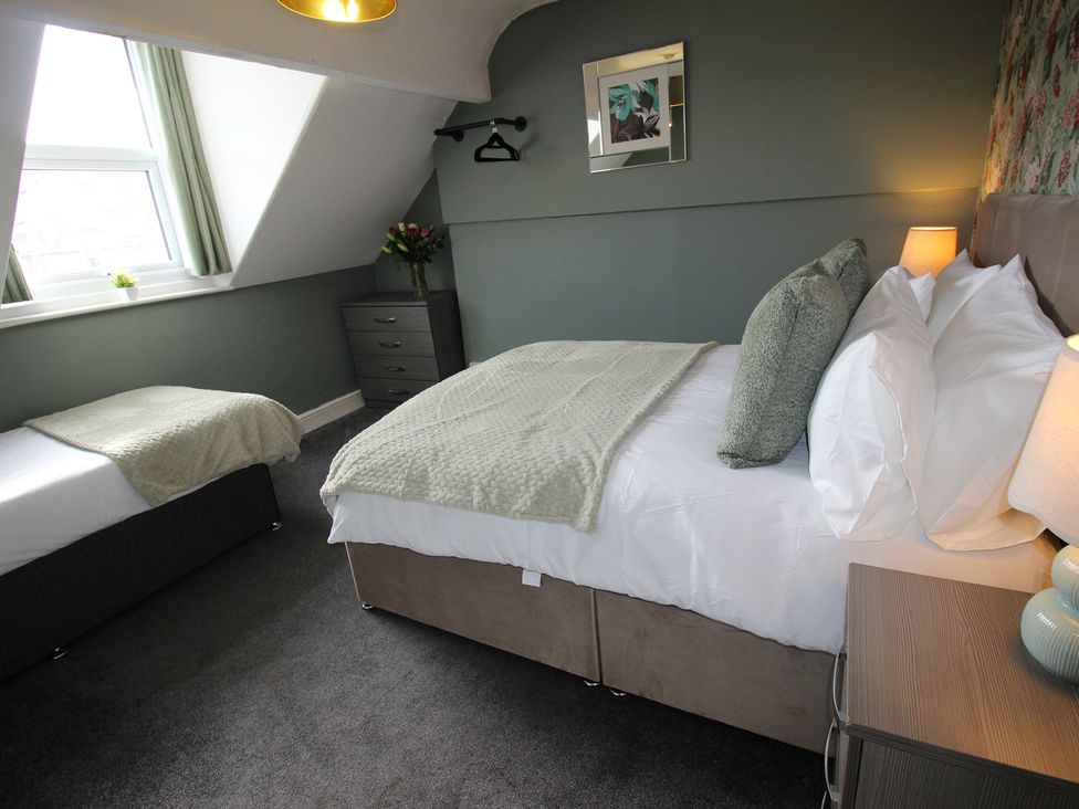 A bedroom with a double bed and a single bed at Cornerhouse Apartment 1 Llandudno