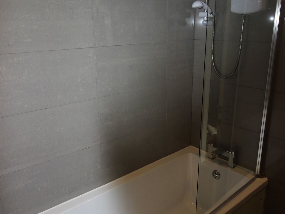 A bathroom with a bathtub and shower at Cornerhouse Apartment 1 Llandudno