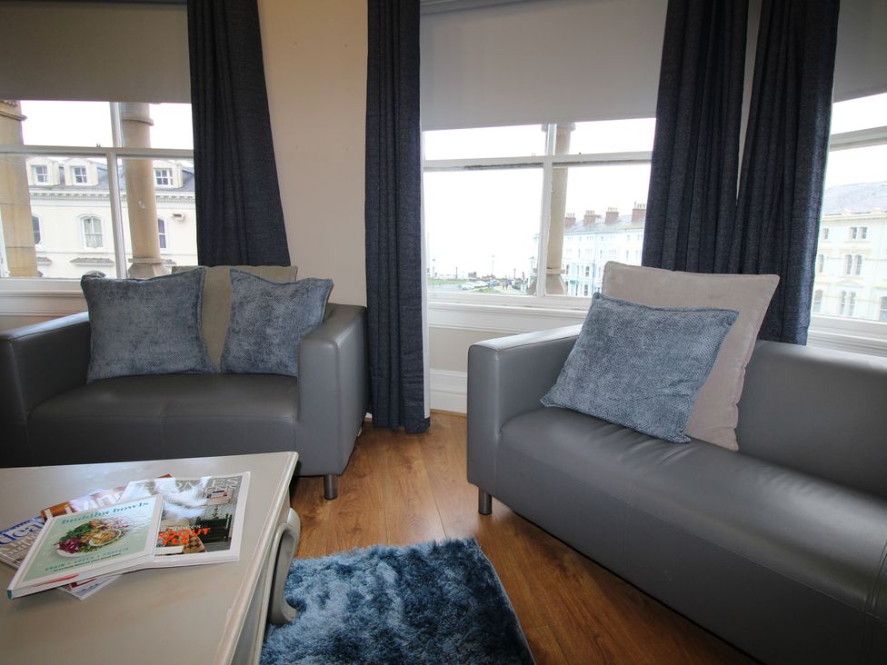 A living room with armchairs and a coffee table at Cornerhouse Apartment 2 in Llandudno