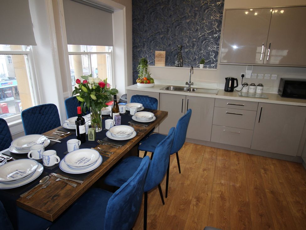 A dining room with a table set for dinner at Cornerhouse Apartment 2 in Llandudno