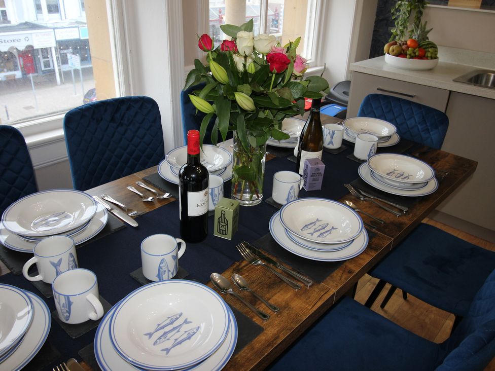 A dining room table set with plates and cutlery at Cornerhouse Apartment 2 in Llandudno