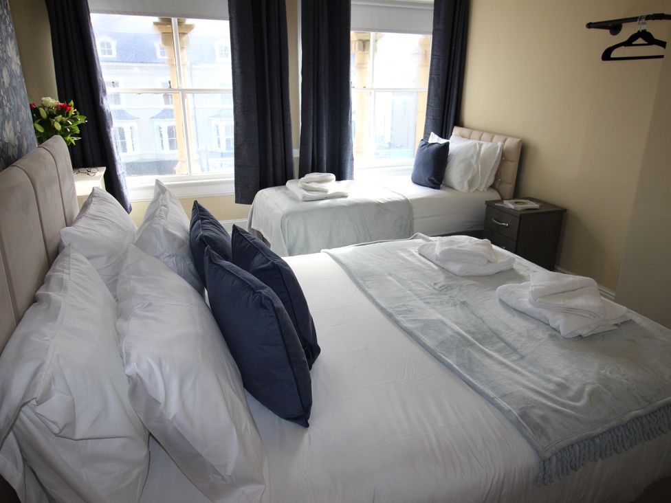 A bedroom with a double bed and a single bed at Cornerhouse Apartment 2 in Llandudno