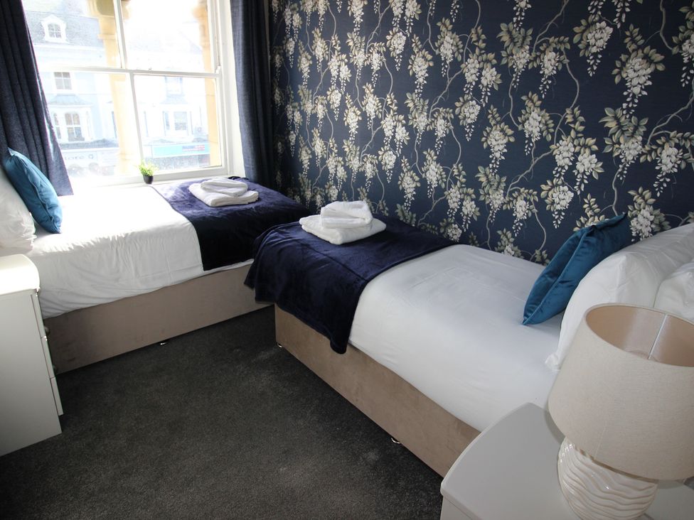 A bedroom with two single beds and a lamp at Cornerhouse Apartment 2 in Llandudno