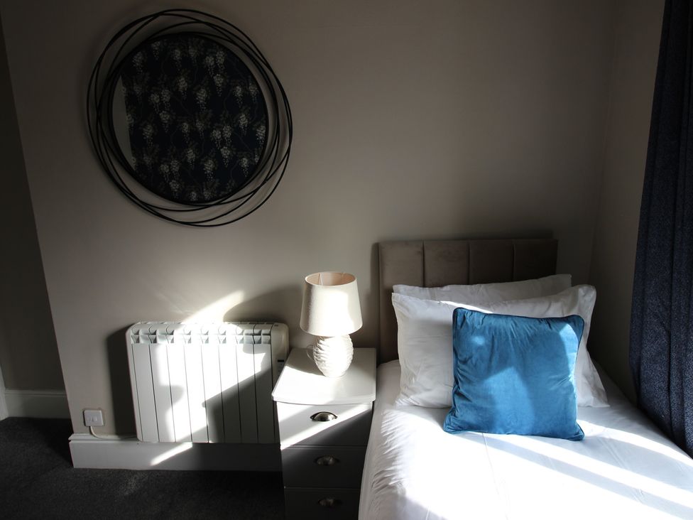 A bedroom with bed and lamp at Cornerhouse Apartment 2 Llandudno