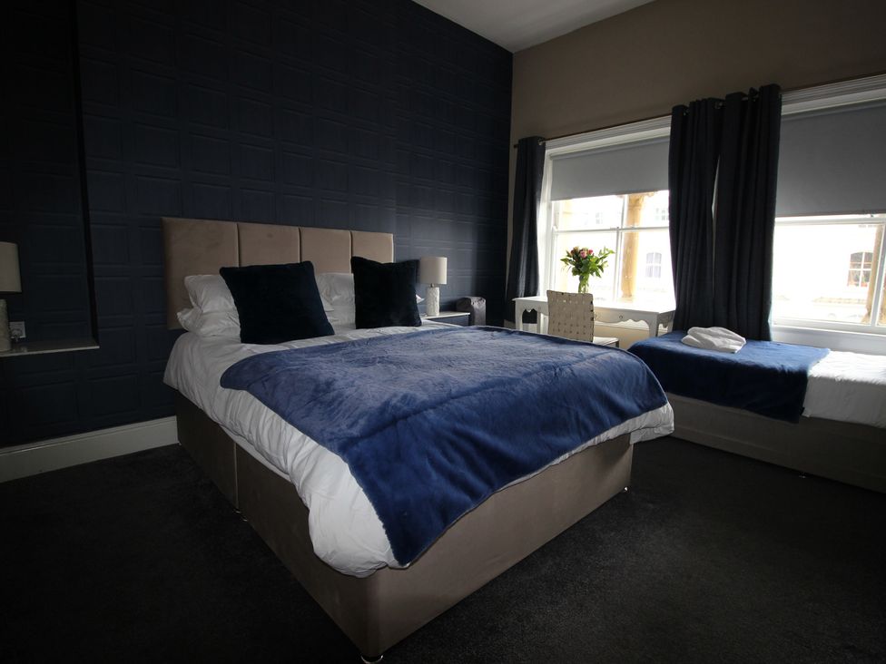 A bedroom with two beds and a window at Cornerhouse Apartment 2 in Llandudno