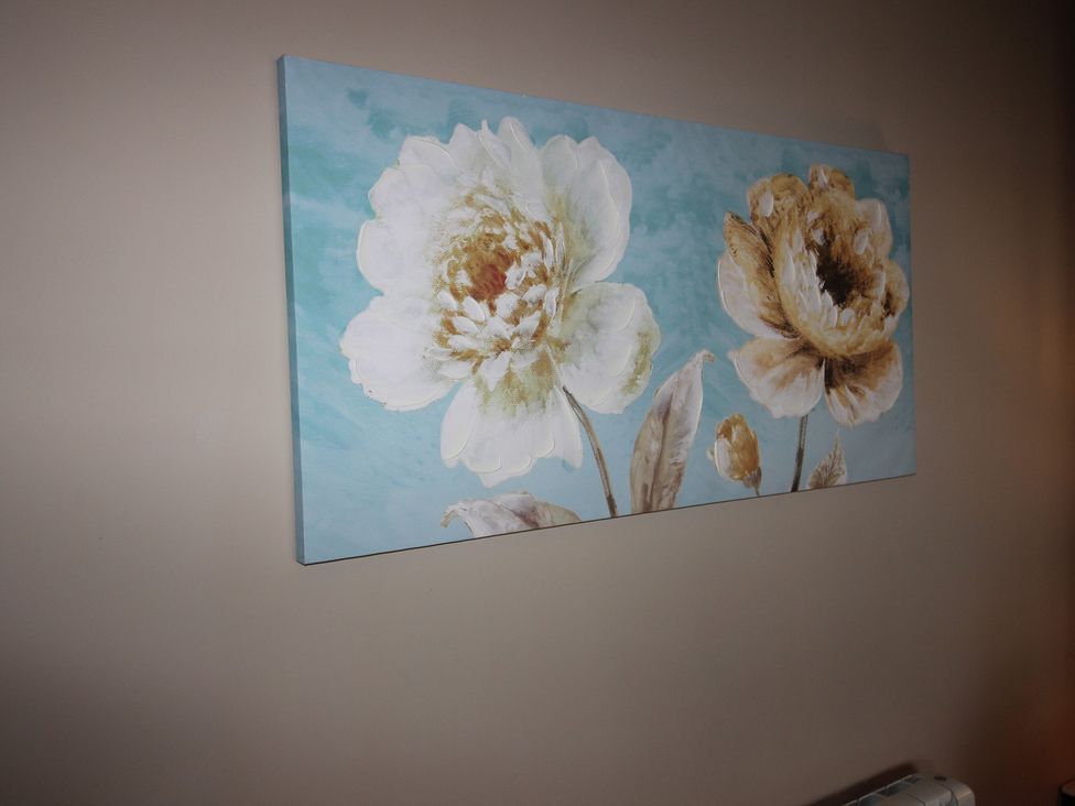 A flower painting on the wall at Cornerhouse Apartment 2 in Llandudno