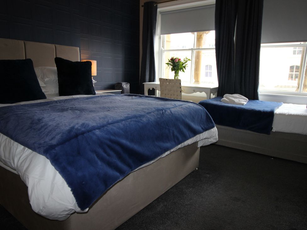 A bedroom with two beds and a window at Cornerhouse Apartment 2 in Llandudno