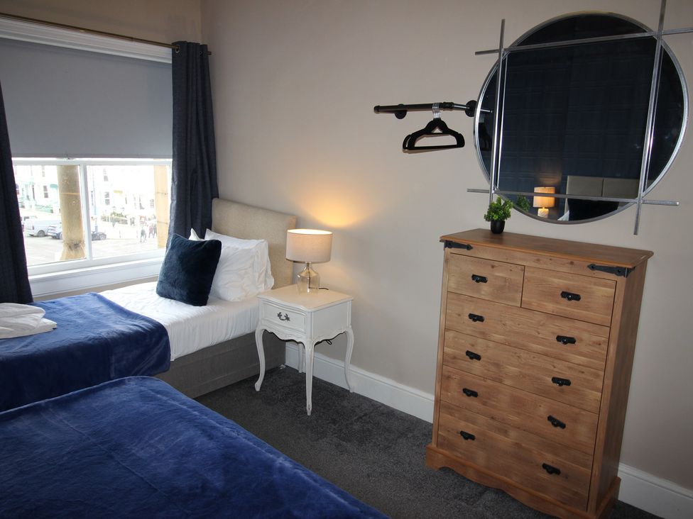 A bedroom with two beds and dresser at Cornerhouse Apartment 2 Llandudno