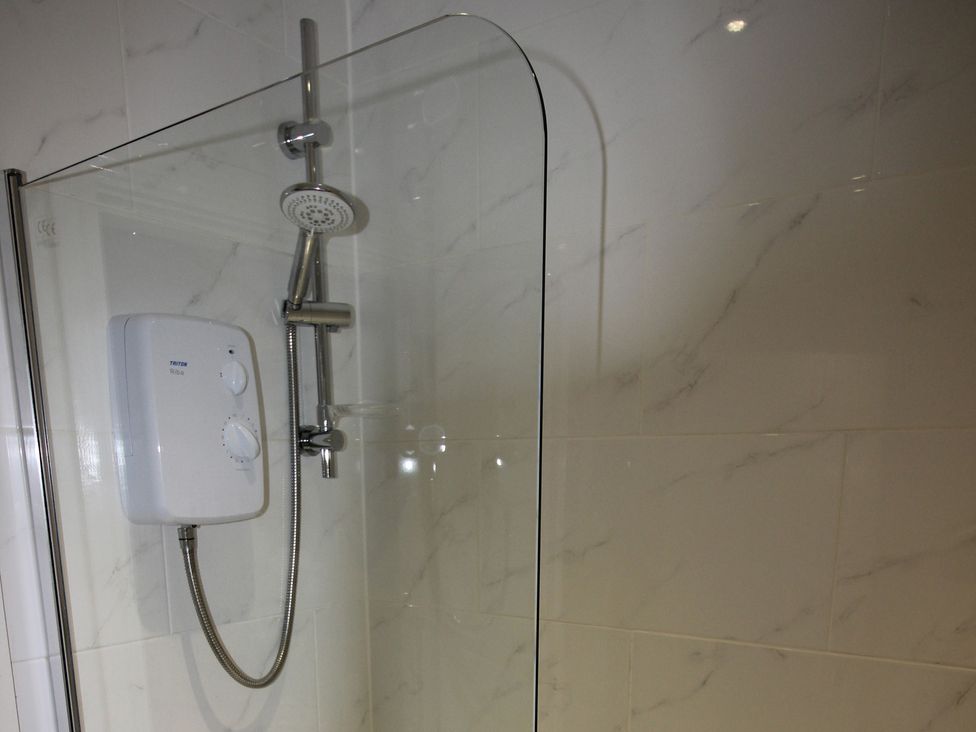 A shower with a control unit and showerhead at Cornerhouse Apartment 2 Llandudno
