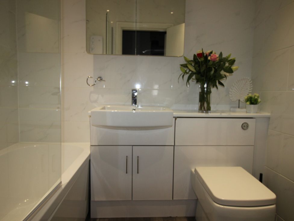 A bathroom with sink, toilet, and bathtub at Cornerhouse Apartment 2 Llandudno