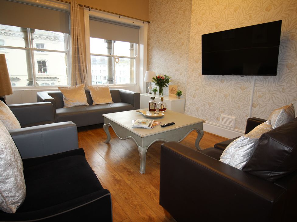 A living room with seating and a television at Cornerhouse Apartment 3 in Llandudno