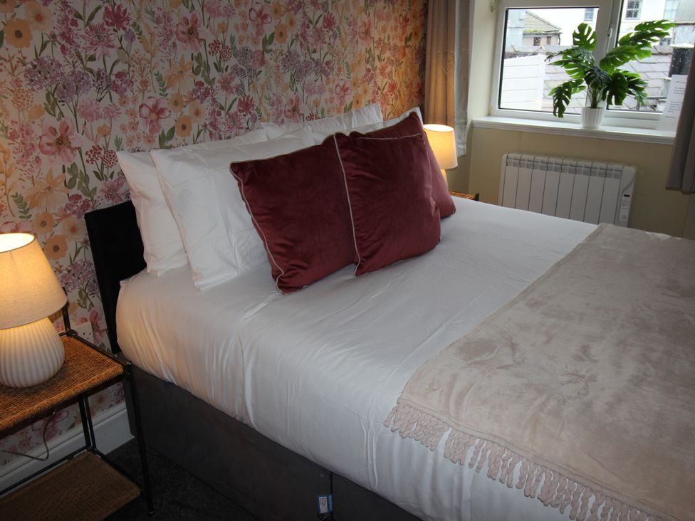 A bedroom with a bed and pillows at Cornerhouse Apartment 3 Llandudno