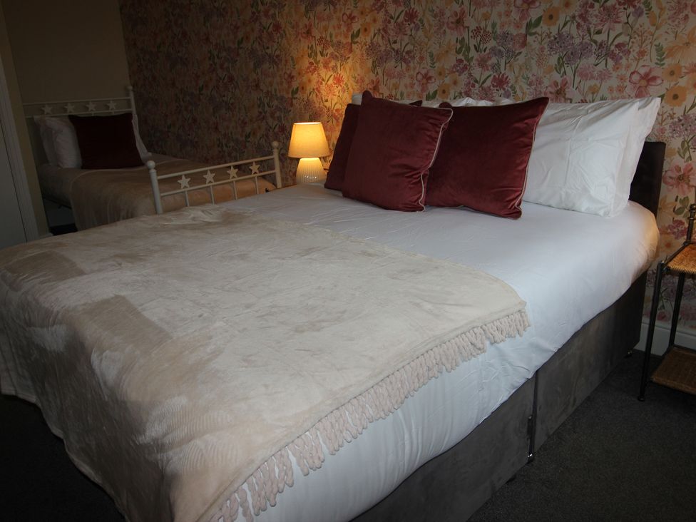A bedroom with a bed and a bedside lamp at Cornerhouse Apartment 3 Llandudno