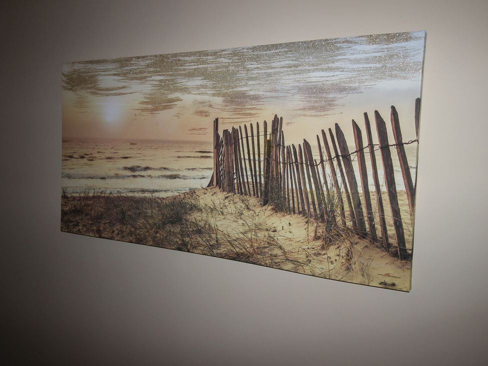 A beach scene with a fence and ocean at Cornerhouse Apartment 3 Llandudno