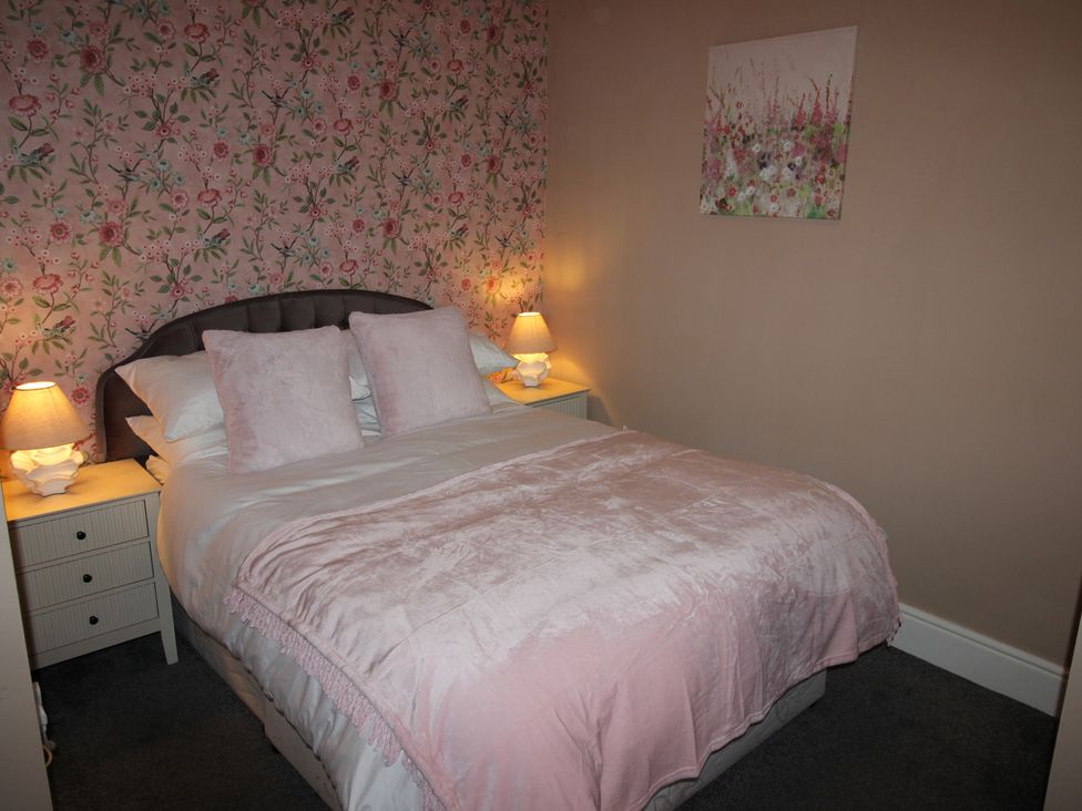 A bedroom with a bed and lamps at Cornerhouse Apartment 3 in Llandudno