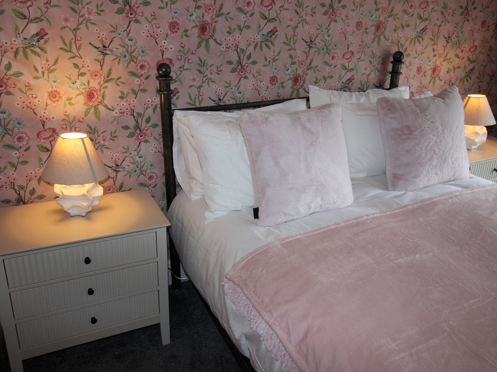 A bedroom with a bed and nightstand at Cornerhouse Apartment 3 in Llandudno