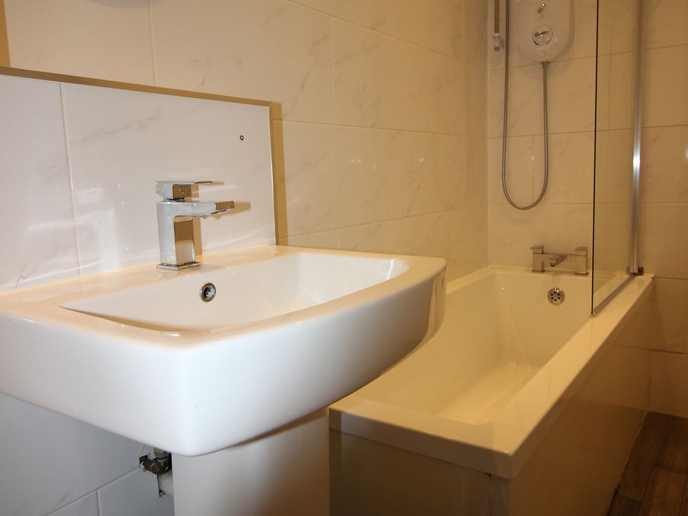 A bathroom with a washbasin and bathtub at Cornerhouse Apartment 3 in Llandudno