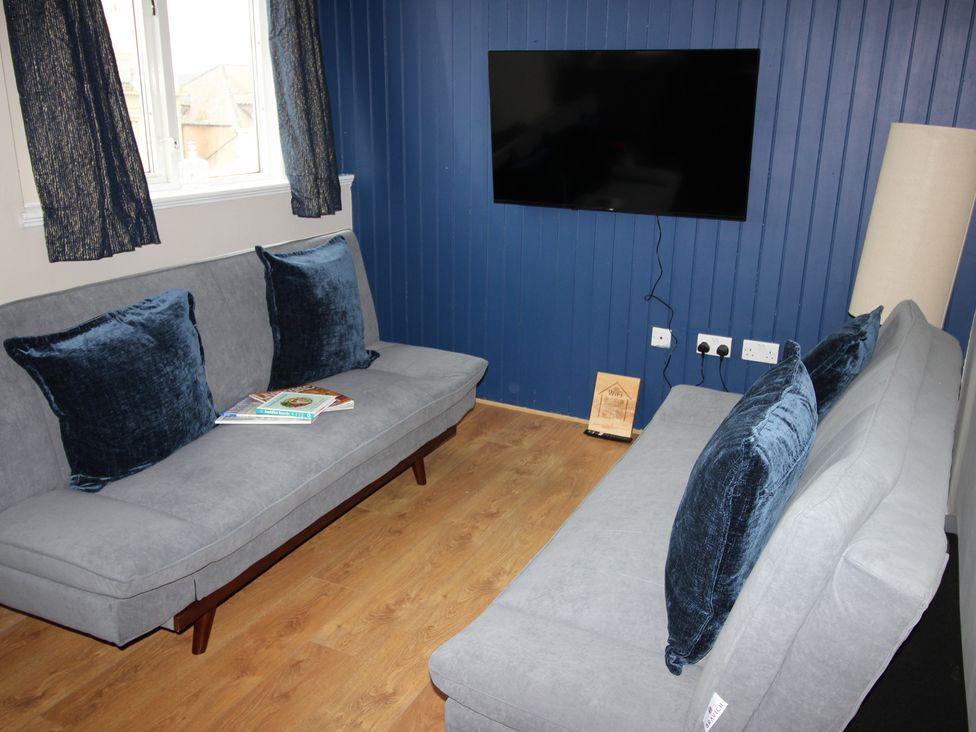 A living room with sofas and a television at Cornerhouse Apartment 4 Llandudno