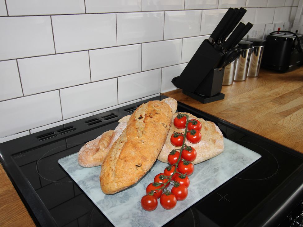 Bread and cherry tomatoes on a marble platter in a kitchen