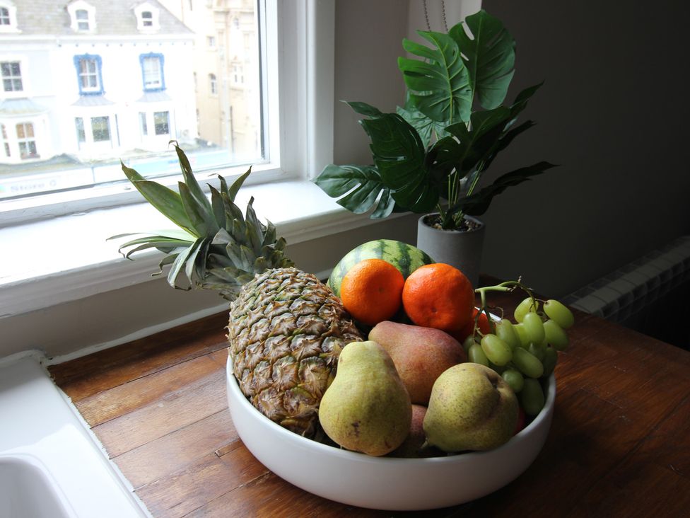 A bowl of fruits on a wooden table at Cornerhouse Apartment 4 in Llandudno