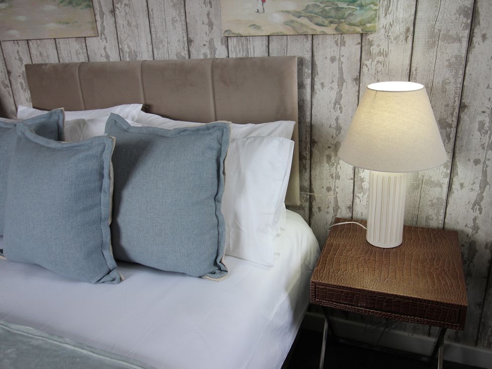 A bedroom with a bed and bedside lamp at Cornerhouse Apartment 4 Llandudno