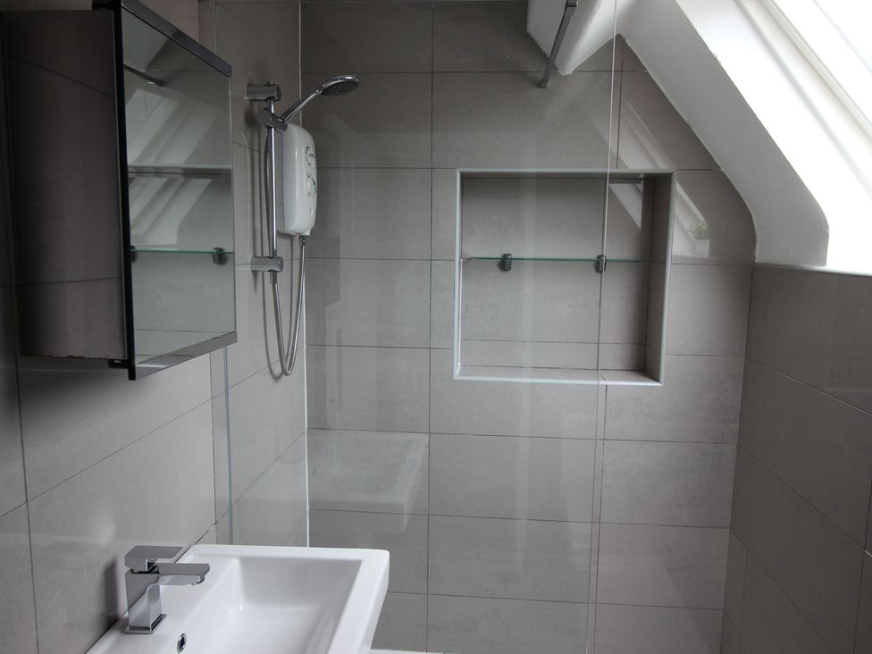 A bathroom with a sink and shower at Cornerhouse Apartment 4, Llandudno