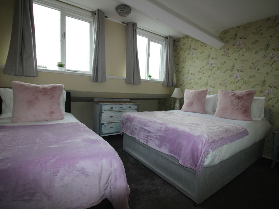 A bedroom with two beds and a dresser at Cornerhouse Apartment 5 in Llandudno