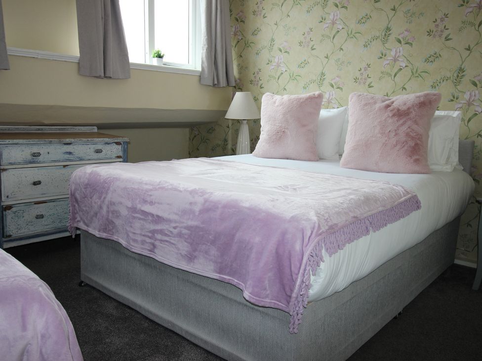 A bedroom with bed and dresser at Cornerhouse Apartment 5 in Llandudno