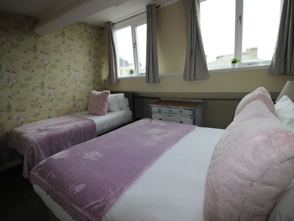 A bedroom with two beds and a dresser at Cornerhouse Apartment 5 in Llandudno