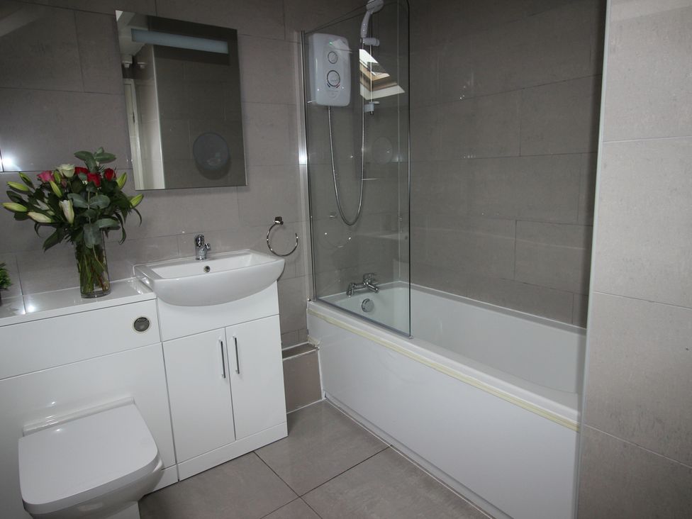 A bathroom with a shower, toilet, sink, and bathtub at Cornerhouse Apartment 5 Llandudno