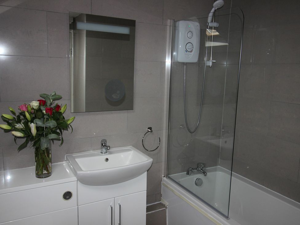 A bathroom with a shower and sink at Cornerhouse Apartment 5 Llandudno