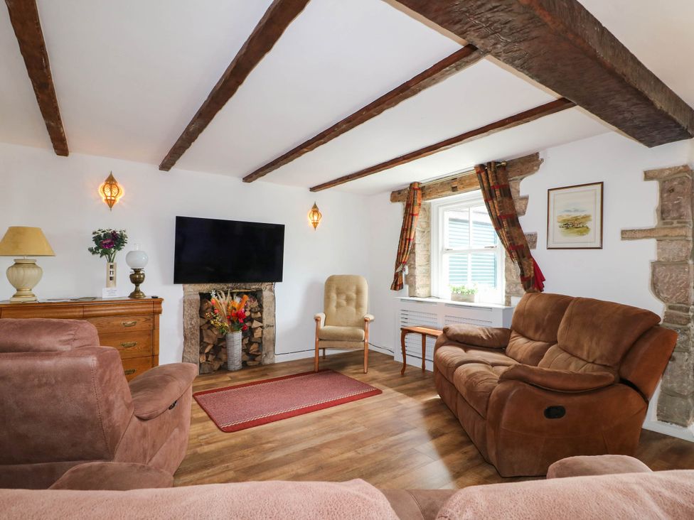 A living room with a television and seating area at Jasmine Cottage in Matlock