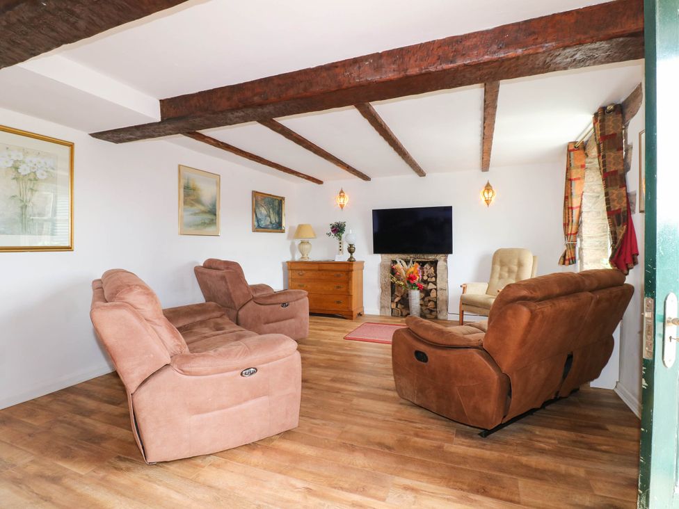 A living room with two sofas and a television at Jasmine Cottage in Matlock
