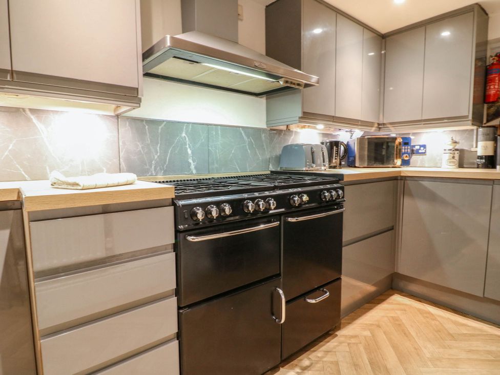 A kitchen with a stove and cabinets at Jasmine Cottage in Matlock