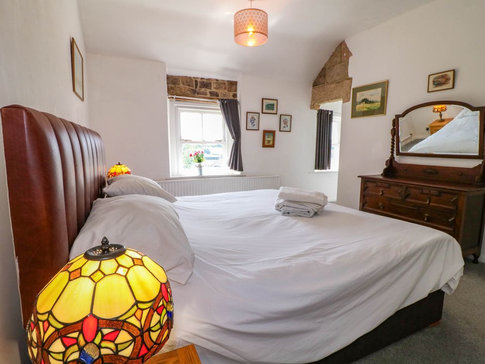 A bedroom with a double bed and a chest of drawers at Jasmine Cottage in Matlock
