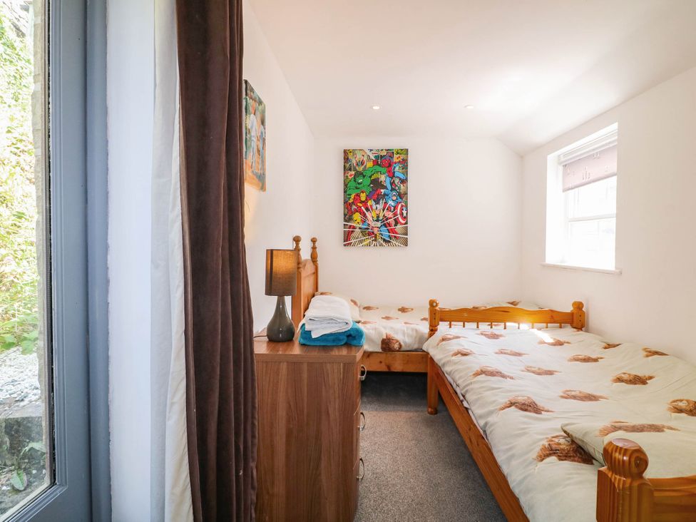 A bedroom with two beds and a dresser at Jasmine Cottage in Matlock