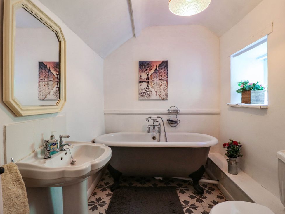 A bathroom with a bath tub and sink at Jasmine Cottage in Matlock
