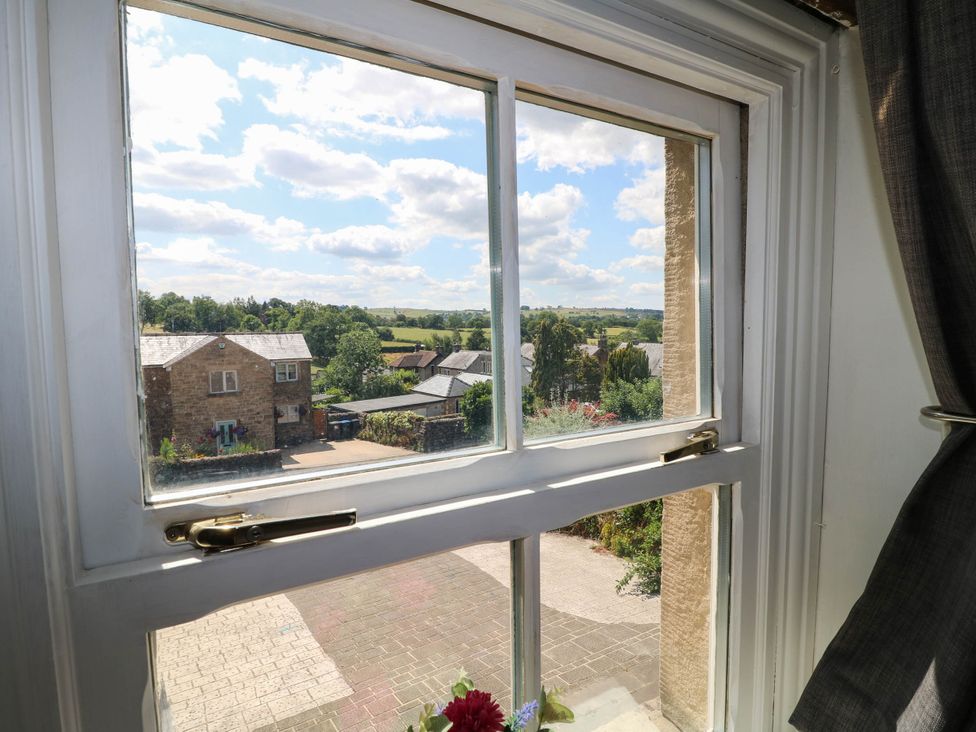 A view from a window showing houses and landscape at Jasmine Cottage in Matlock