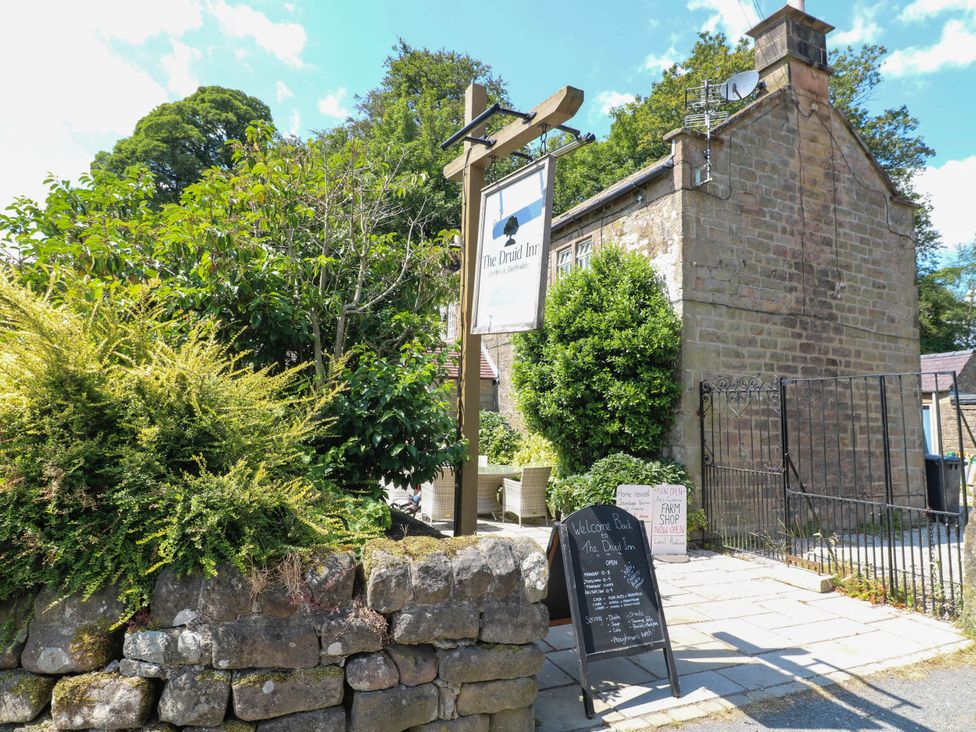 An inn with a sign and menu board at The Druid Inn in Matlock