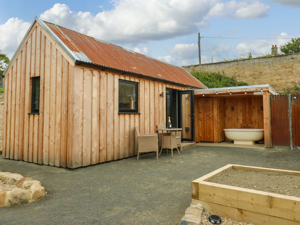 A wooden house with outdoor seating and a bathtub at 2 West Dunkirk Neuk Hexham