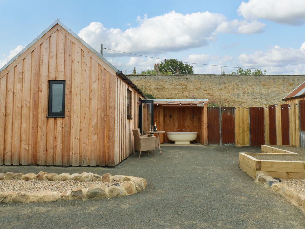 An outdoor area with a wooden house and bathtub at 2 West Dunkirk Neuk Hexham