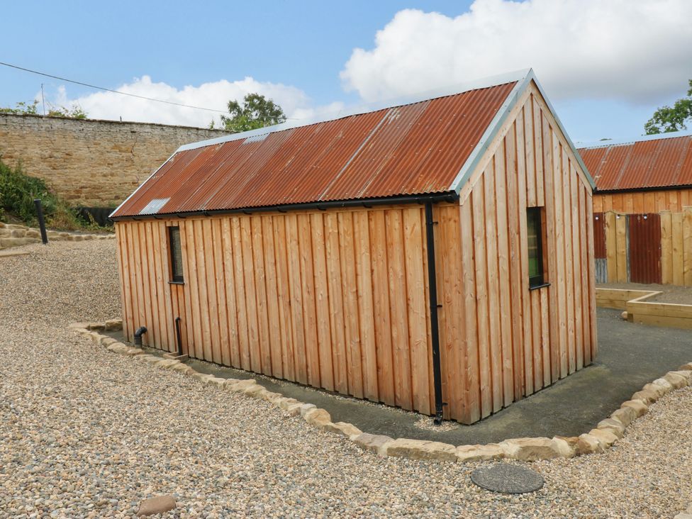 A wooden building with a corrugated roof and gravel surroundings at 2 West Dunkirk Neuk Hexham