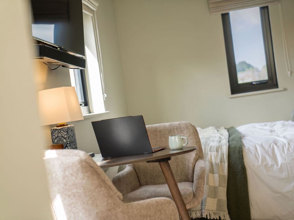 A bedroom with a laptop on a table and a cup on it at 2 West Dunkirk Neuk Humshaugh