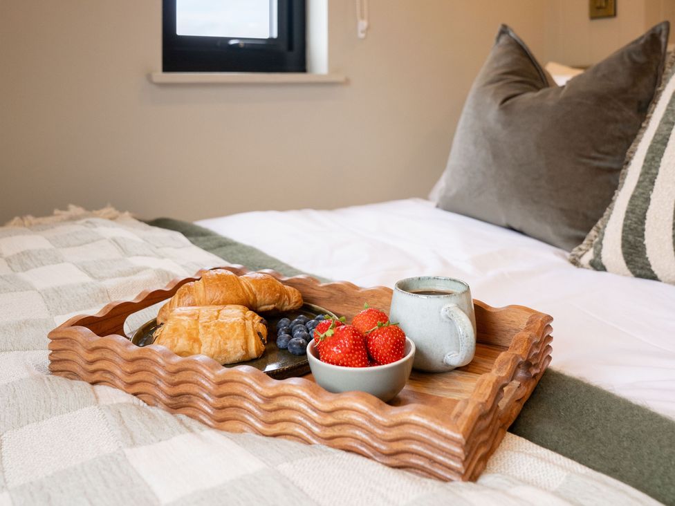 A tray with croissants and fruit on a bed at 2 West Dunkirk Neuk Humshaugh