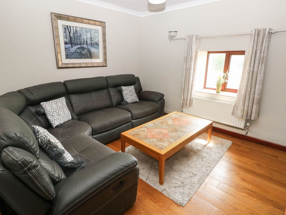 A living room with a sofa and a coffee table at Coedllys Uchaf Cottage