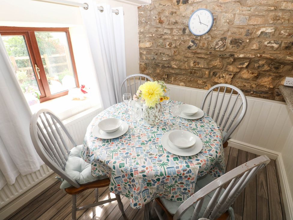 A dining room with a round table and chairs at Coedllys Uchaf Cottage in 