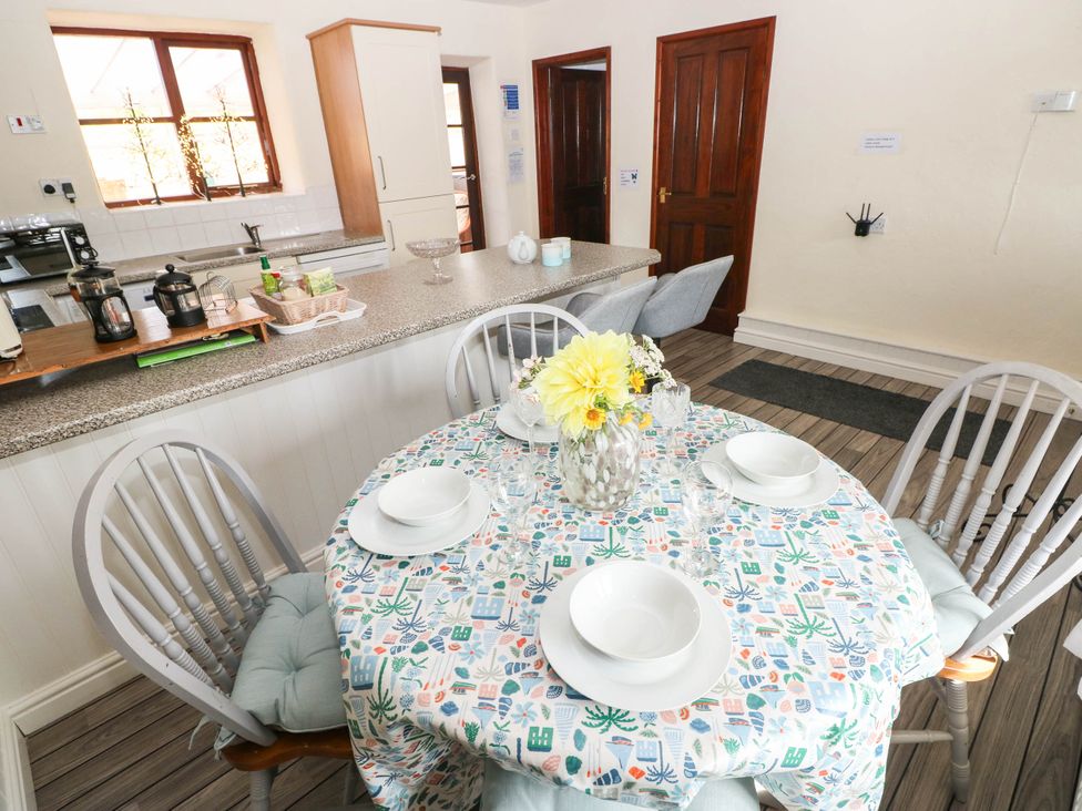A dining room with a table set for meals at Coedllys Uchaf Cottage